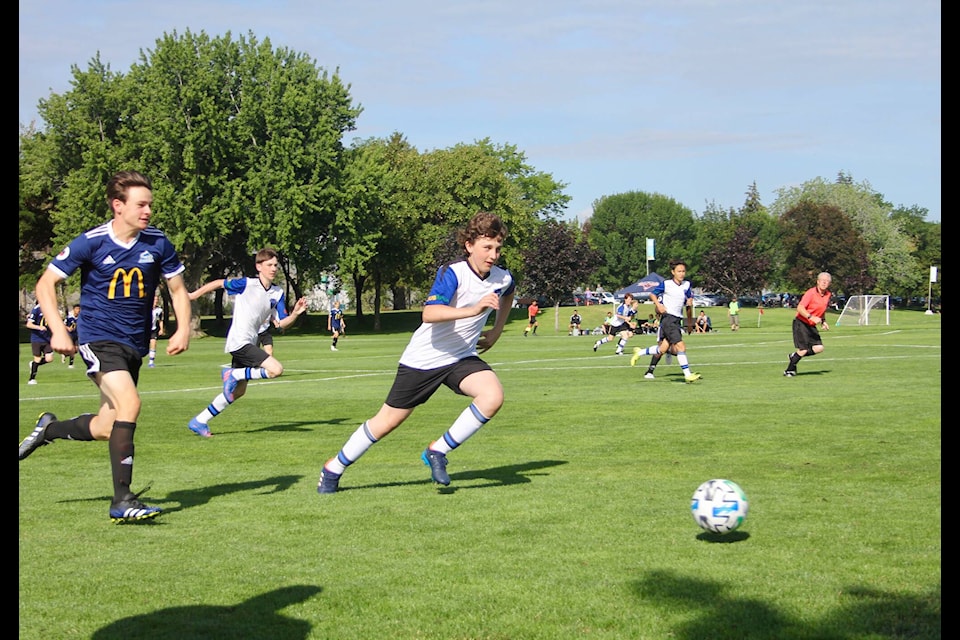 Griffin Carmont, a defender on Williams Lake FC, races down the sidelines to beat a Pinnacles FC player to the ball. (Lauren Keller photo - 100 Mile Free Press)