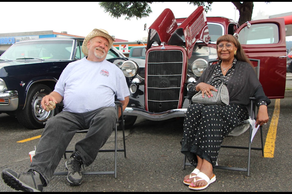 Carl and Dianne Rogers relax in front of their 1935 Model 48 Ford in the A&W parking lot Friday during opening registration for Hot July Nights. (Patrick Davies photo - 100 Mile Free Press)