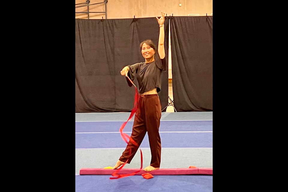 Sang-Hee Robinson, coach of South Cariboo Rhythmic Gymnastics, demonstrates the ribbons. (Fiona Grisswell photo - 100 Mile Free Press)