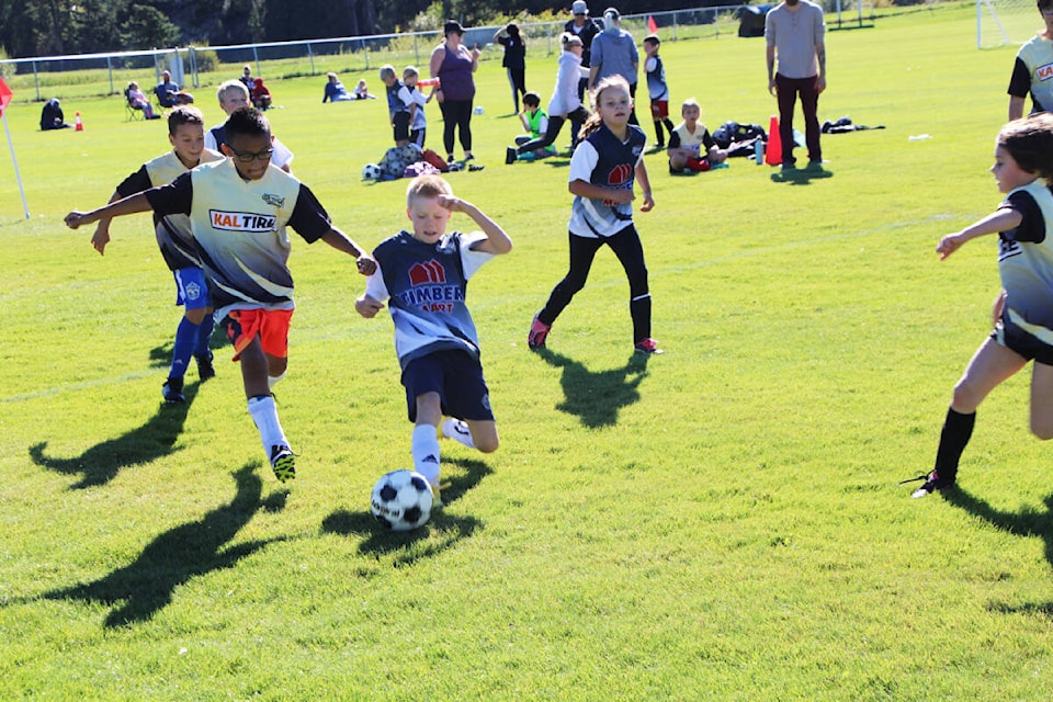 Timbermart U10 player Elias Bird slides forward to kick the ball away from Kal Tire U10 player Austin Boyce-Archie. (Patrick Davies photo - 100 Mile Free Press)