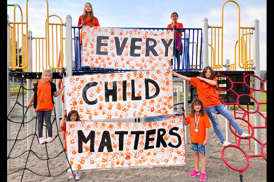 Students at 100 Mile Elementary School hold up their Every Child Matters banners. Going from top to bottom and left to right: Eva Smith, Lilia Sawyer-Ned, Micki Sawyer-Ned, Maci Van Schaik, Jori Sawyer-Ned and Elsa Van Schaik. (Fiona Grisswell photo - 100 Mile Free Press)