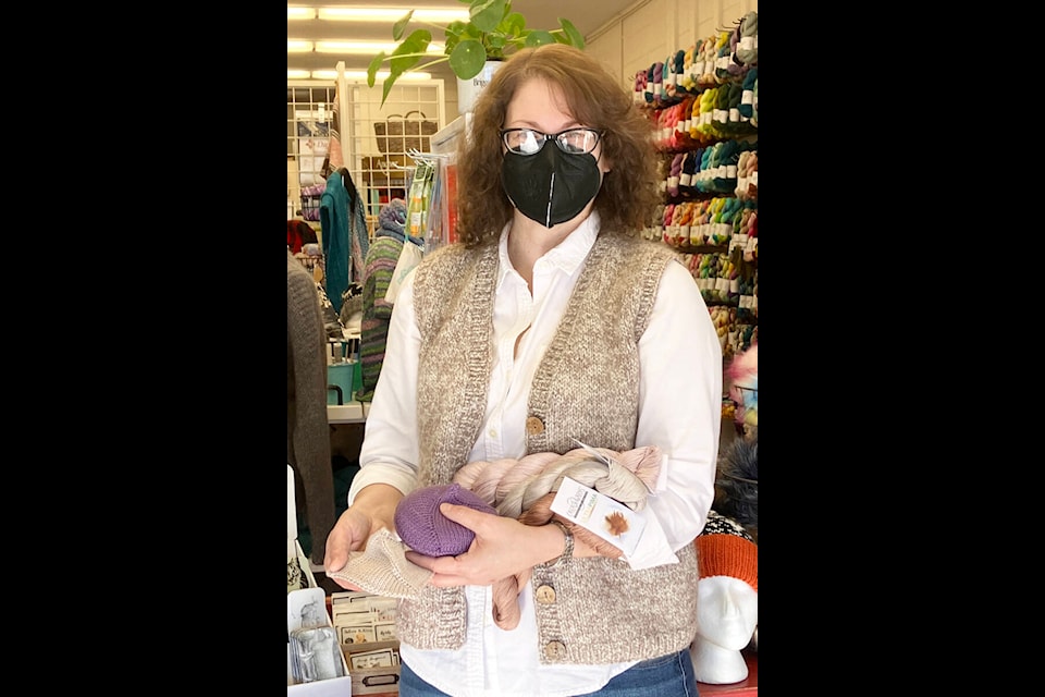 Andie Giddings, owner of Impossible Knot Yarn Shop on Birch Ave. in 100 Mile House holds two Knitted Knockers. The purple is based on the Alberta pattern while the grey knocker follows the Canada pattern. (Fiona Grisswell photo - 100 Mile Free Press)