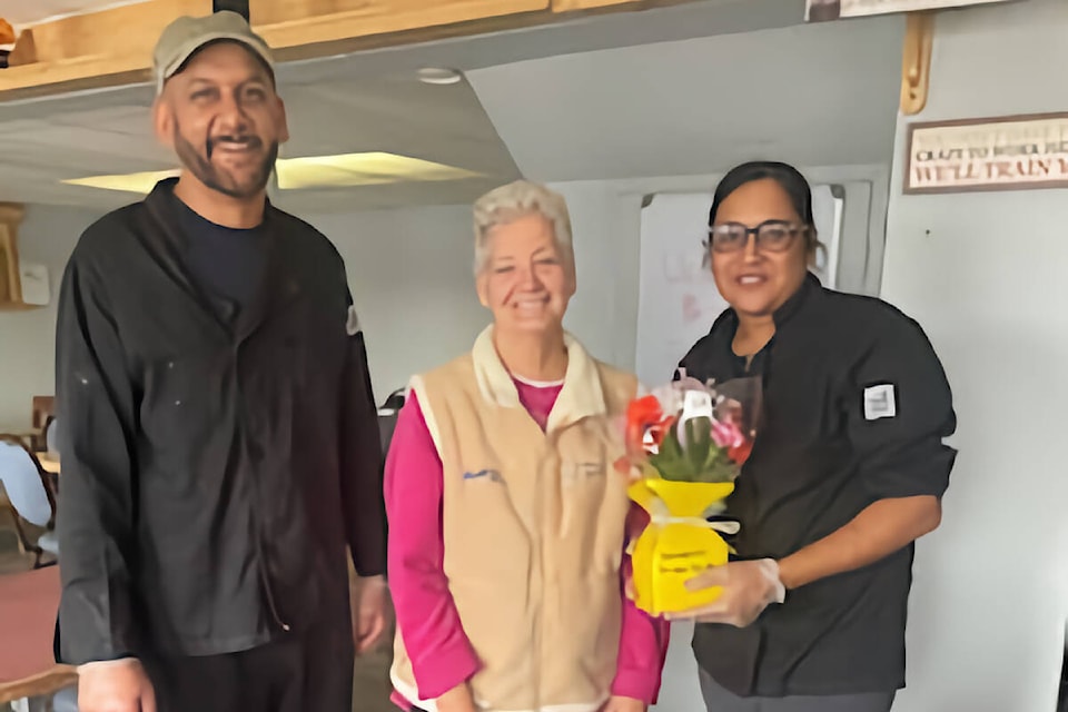 Judy Boehm (centre) welcomed Palwinder Singh and Manpreet Kaur Padda, the new owners of the Hungry Bear Diner, with a bouquet of flowers. (Photo submitted)
