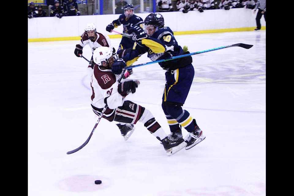 100 Mile House Wrangler Nathan Bohmer checks Revelstoke Grizzly Carson Reinson to the ice during Friday night’s game. (Patrick Davies photo - 100 Mile Free Press)