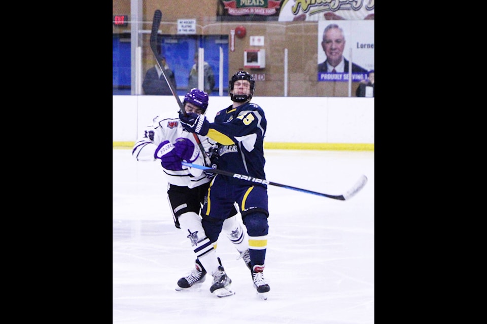 100 Mile House Wrangler Owen Johnson collides with North Okanagan Knight Luke Rishaug during a game at the South Cariboo Rec Centre Friday night. (Patrick Davies photo - 100 Mile Free Press)