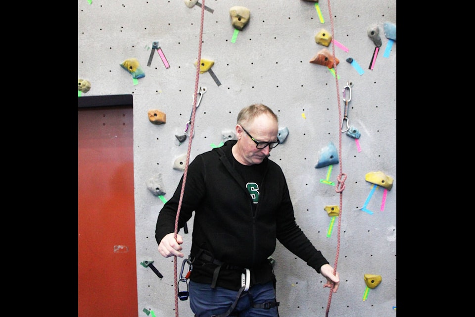 Ken MacKenzie checks some climbing ropes before students use them to climb the rock wall. (Patrick Davies photo - simplymastery)