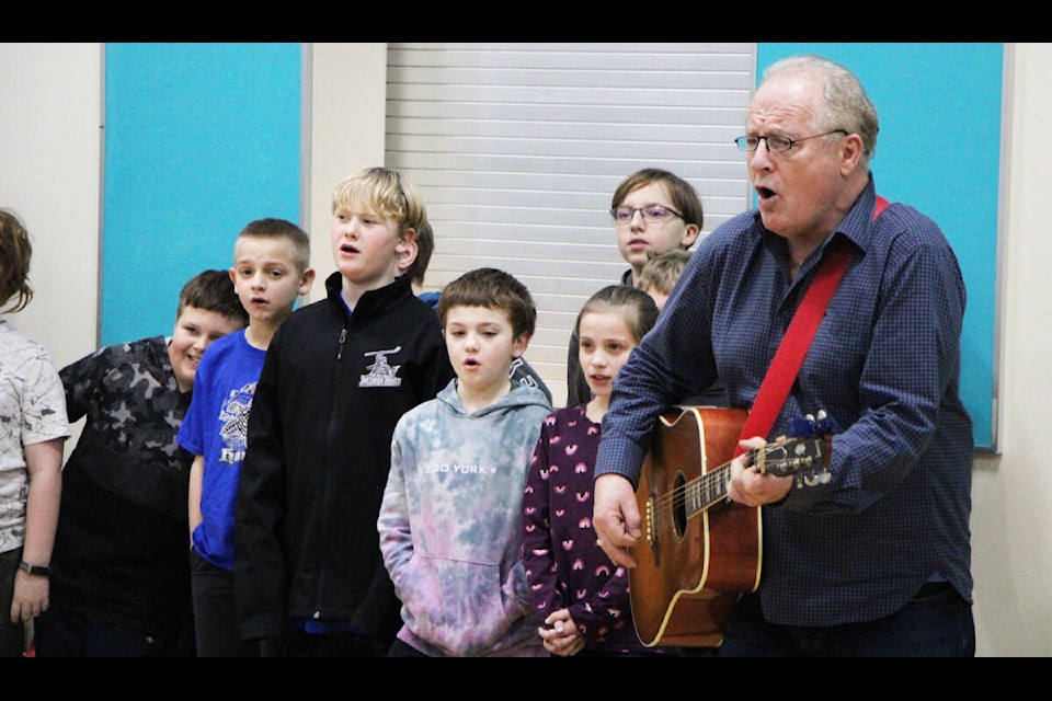 Musician Norman Foote performs a song written by the students of Mile 108 Elementary’s Grade 3-4 class. Foote visited several schools in the South Cariboo last week to teach students how to write music. See story, photos A9. (Patrick Davies photo - 100 Mile Free Press)