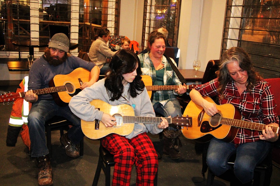 Arlene Tanner (front) left and her mom Jennifer Tanner learn how to play guitar with Matt Benz (back left) and Melanie van Bynen. (Patrick Davies photo - 100 Mile Free Press)