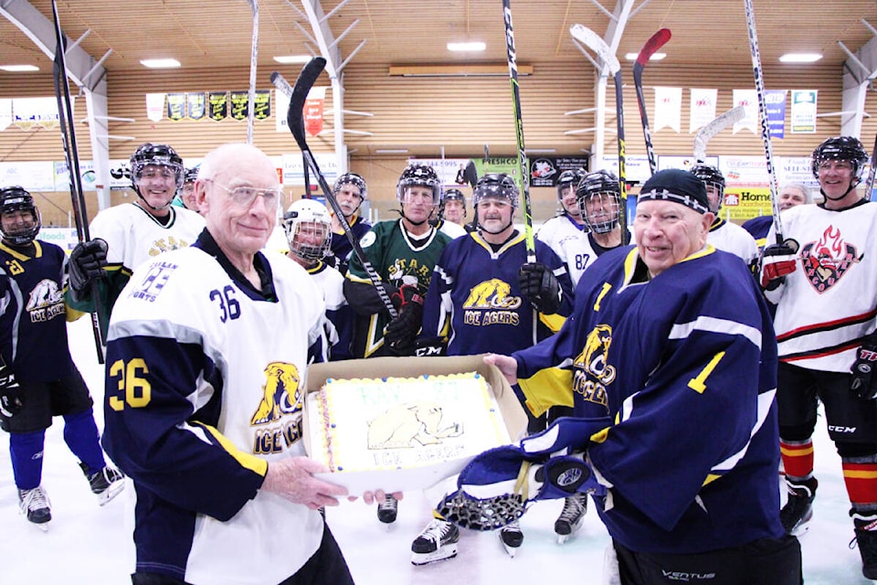 The 100 Mile House Ice Agers had Ron Graves, 86, present Ray Carlson, 87, with a cake to celebrate his birthday at their game last week. The two octogenarians have been playing hockey for close to half of their lives. (Patrick Davies photo - 100 Mile Free Press)