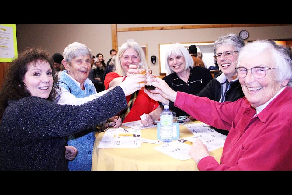 Attendees of the first annual Caribrew Beer Fest toast at the 100 Mile Community Hall. (Patrick Davies photo - 100 Mile Free Press)