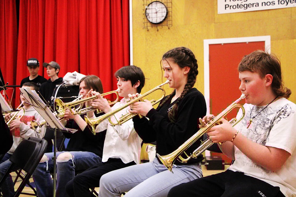 Nadia Kulyk (centre) shows Kolton Kitchell and Ty Williams how to play the trumpet during a concert at 100 Mile Elementary School last week. (Patrick Davies photo - simplymastery)