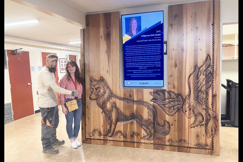 Spirit Carver Dean and Penny Reid, 100 Mile Elementary School’s Indigenous support worker, stand beside the new art that graces the entrance way of 100 Mile Elementary. (Fiona Grisswell photo - simplymastery)