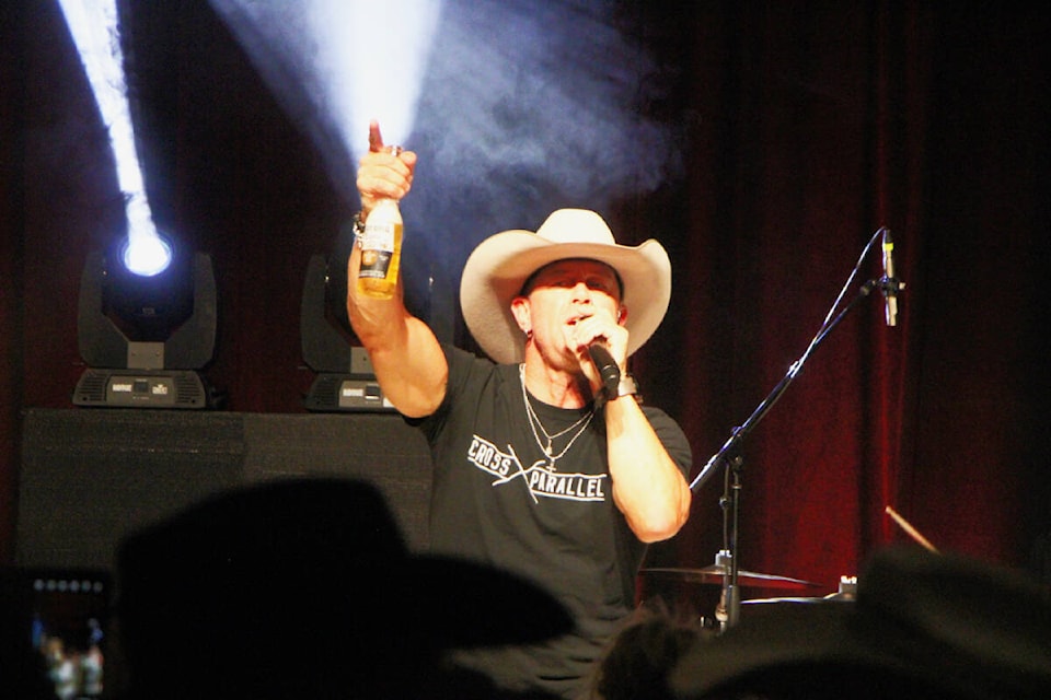 Aaron Prichett holds up a beer as he performs live in 100 Mile House last Saturday. (Patrick Davies photo - simplymastery)