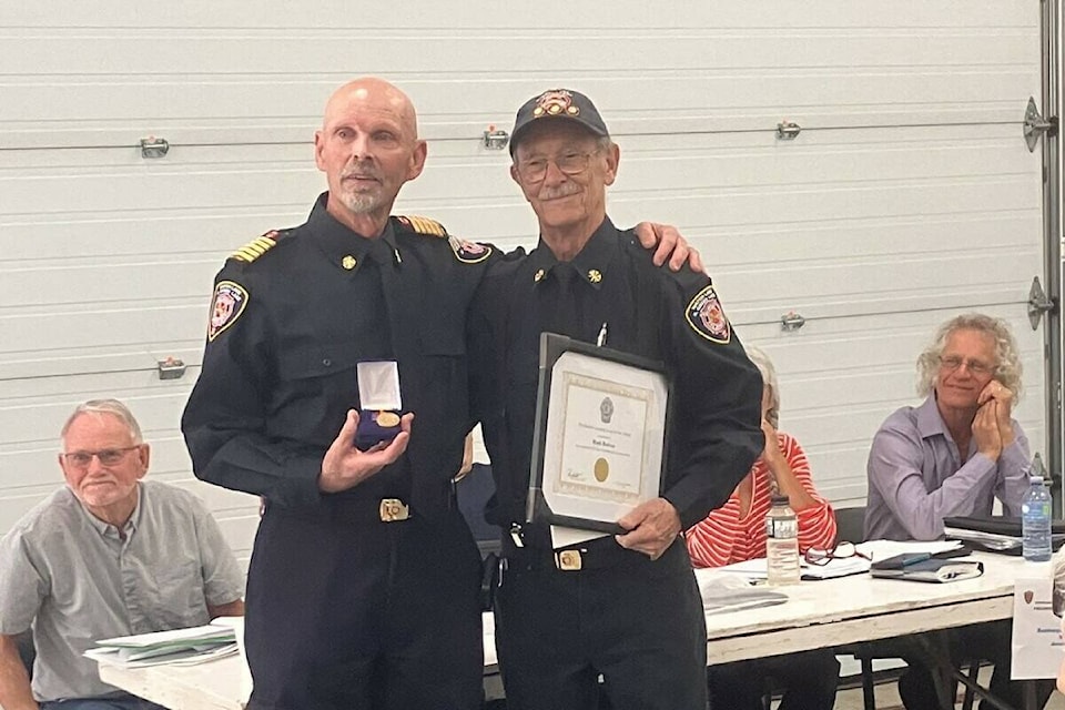 Chief Andy Palaniak (left) of the Watch Lake-North Green Lake Volunteer Fire Department presents long-time member Mark Bulman with a certificate of appreciation for his years of service. Bulman has worked with the Watch Lake-North Green Lake Volunteer Fire Department for over 27 years and says the community has become the most prominent aspect of his life. (Fiona Grisswell photo - 100 Mile Free Press)