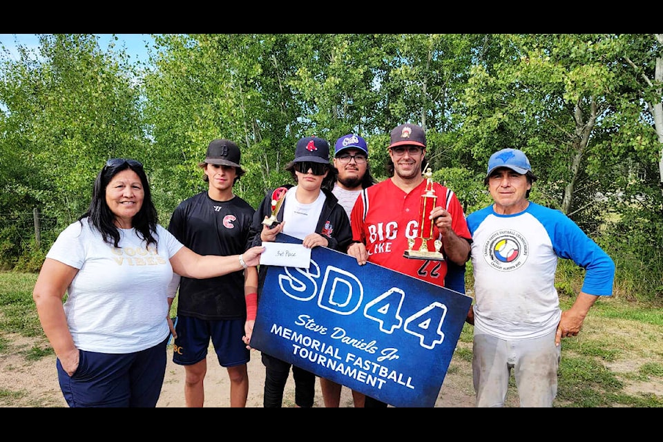 Denise Archie (left) presents members of the Big Guy Lake team with the third-place trophy and rookie trophy during the Steve Daniels Jr. Memorial Fastball Tournament. (Photo submitted)