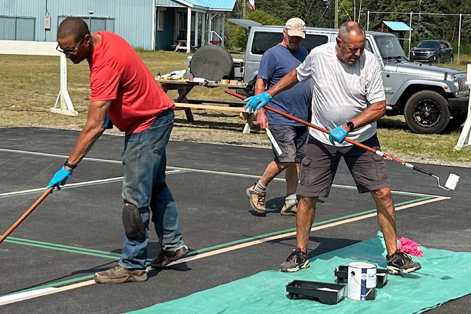 Community members, Interlakes staff, and pickleball enthusiasts all came together to paint the new outdoor courts at the Interlakes Community Centre. (Contributed to simplymastery—by Barb Pearce)