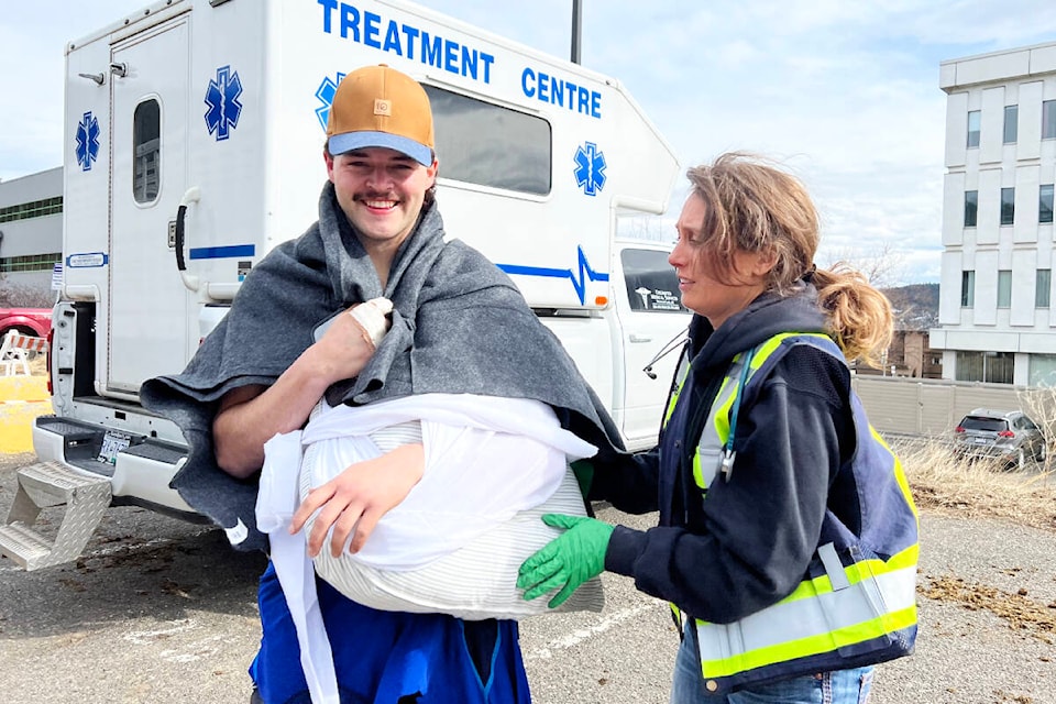 Bull Fighter Cody Call is tended to by Kendra Rolston of Unlimited Medical Services Saturday, April 15 after getting hit by a bull. He suffered a serious shoulder separation. (Angie Mindus photo - Williams Lake Tribune)