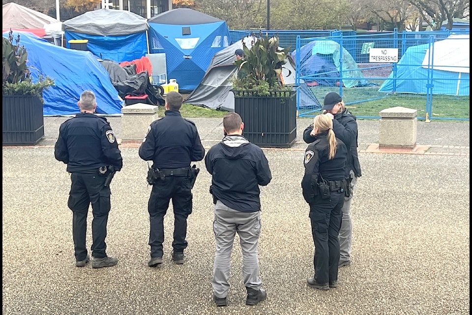Police and bylaw officers stand by the homeless encampment outside of Abbotsford City Hall on Tuesday, Nov. 19. 