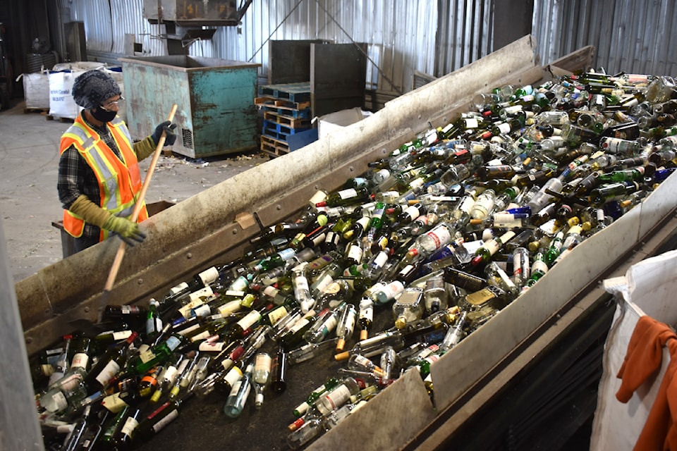 A worker sorts glass inside the Enviro-Corp Recycling facility in Abbotsford. 