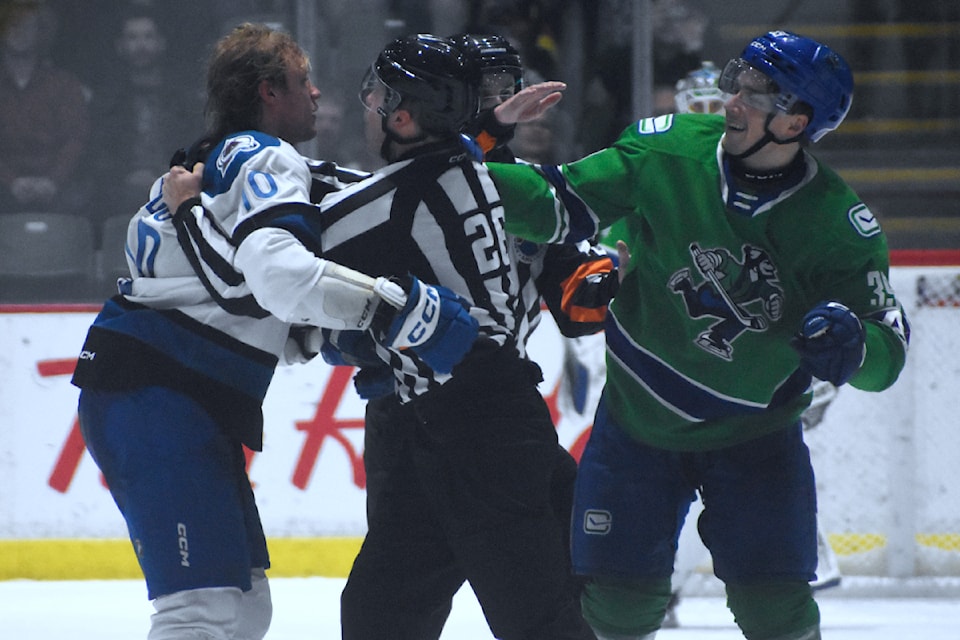 Abbotsford's Ty Mueller tussles with Colorado's John Ludvig on Saturday (Feb. 15). 