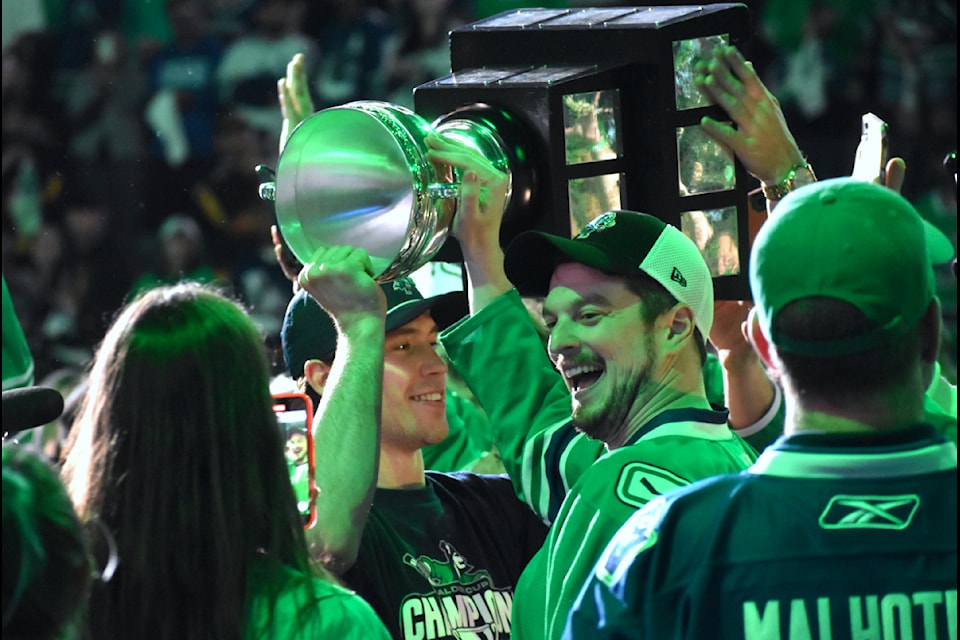Chase Wouters walks through the crowd carrying the Calder Cup. 