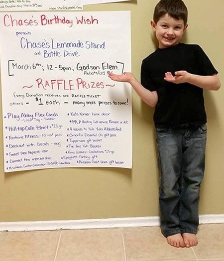Chase shows a poster promoting his lemonade stand and bottle drive this Sunday.