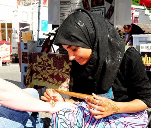 Rabia Sohail applies henna art to Berrybeat visitor. John Morrow