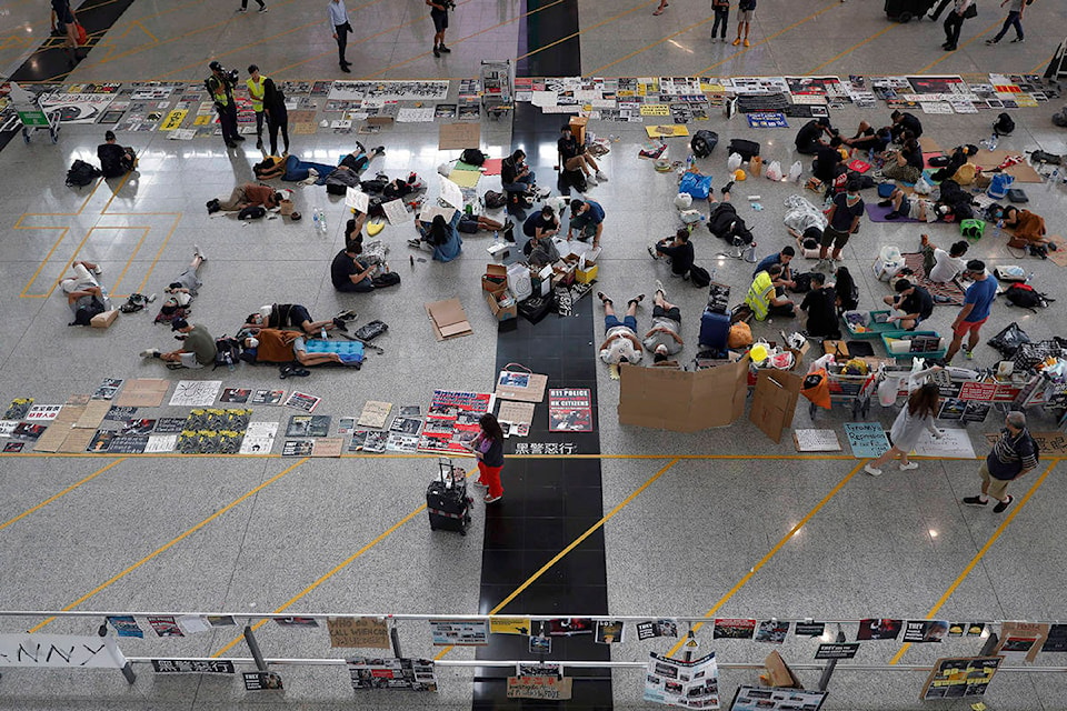 Protesters continue their sit-in rally at the airport in Hong Kong, Wednesday, Aug. 14, 2019. Flight operations resumed at the airport Wednesday morning after two days of disruptions marked by outbursts of violence highlighting the hardening positions of pro-democracy protesters and the authorities in the Chinese city that’s a major international travel hub. (AP Photo/Vincent Thian)