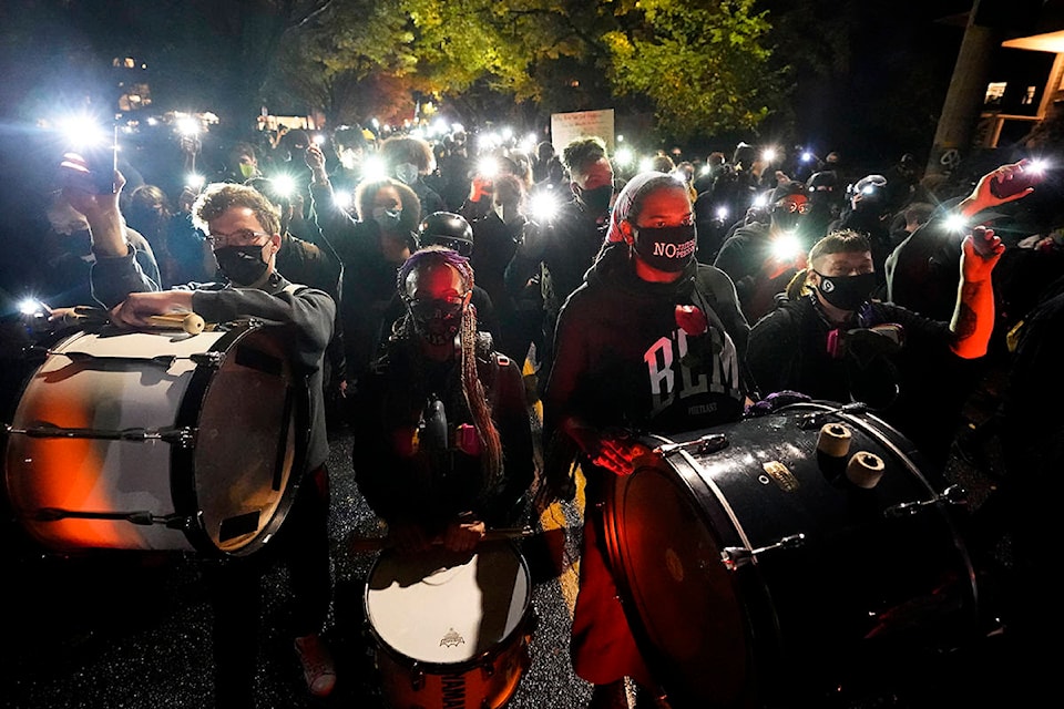 People use the lights on their phones as they march on the night of the election, Tuesday, Nov. 3, 2020, in Portland, Ore. (AP Photo/Marcio Jose Sanchez)