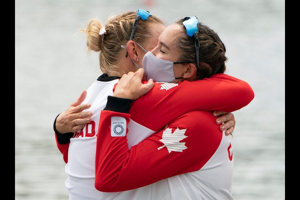 Canada’s Christine Roper and Andrea Proske hug as they wait on the podium after winning the gold medal in women’s eight rowing competition at the Tokyo Olympics, Friday, July 30, 2021 in Tokyo, Japan. (THE CANADIAN PRESS/Adrian Wyld)