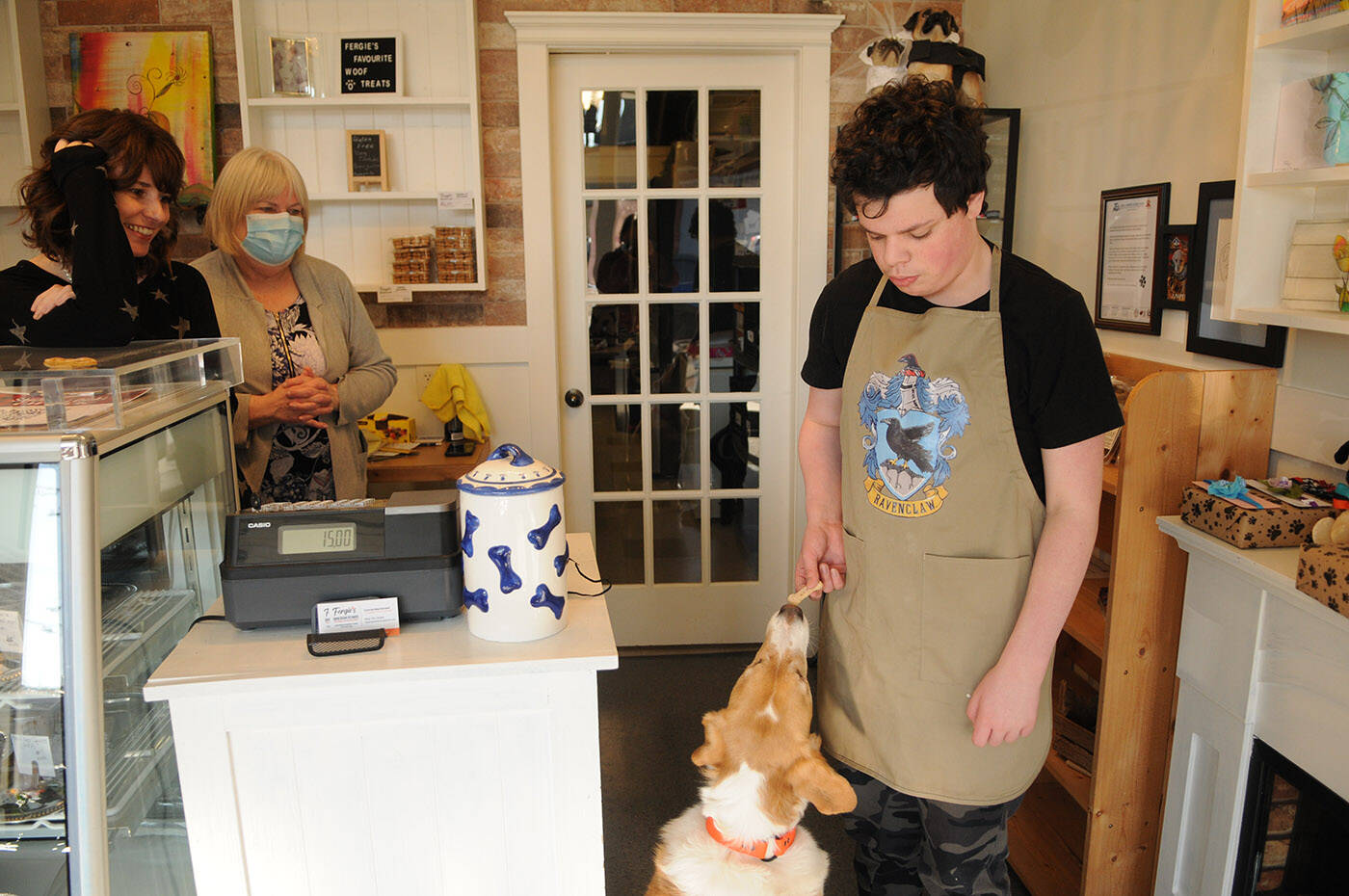 Ryder Newhouse, 14, gives his unofficial therapy dog Tommy a treat. He is making and selling dog cookies to raise money for BC and Alberta Guide Dogs. (Jenna Hauck/ Chilliwack Progress)