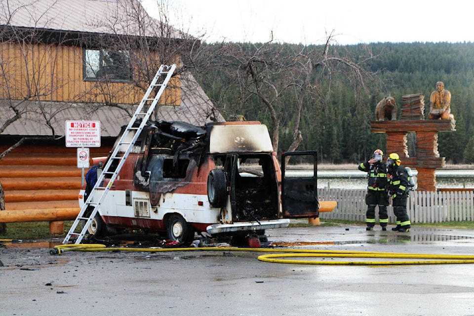 100 Mile Fire Rescue Members clean up the scene after putting out a fire that torched Wendell Smitheram’s van by the South Cariboo Visitor’s Centre on Monday. (Patrick Davies photo - 100 Mile Free Press)