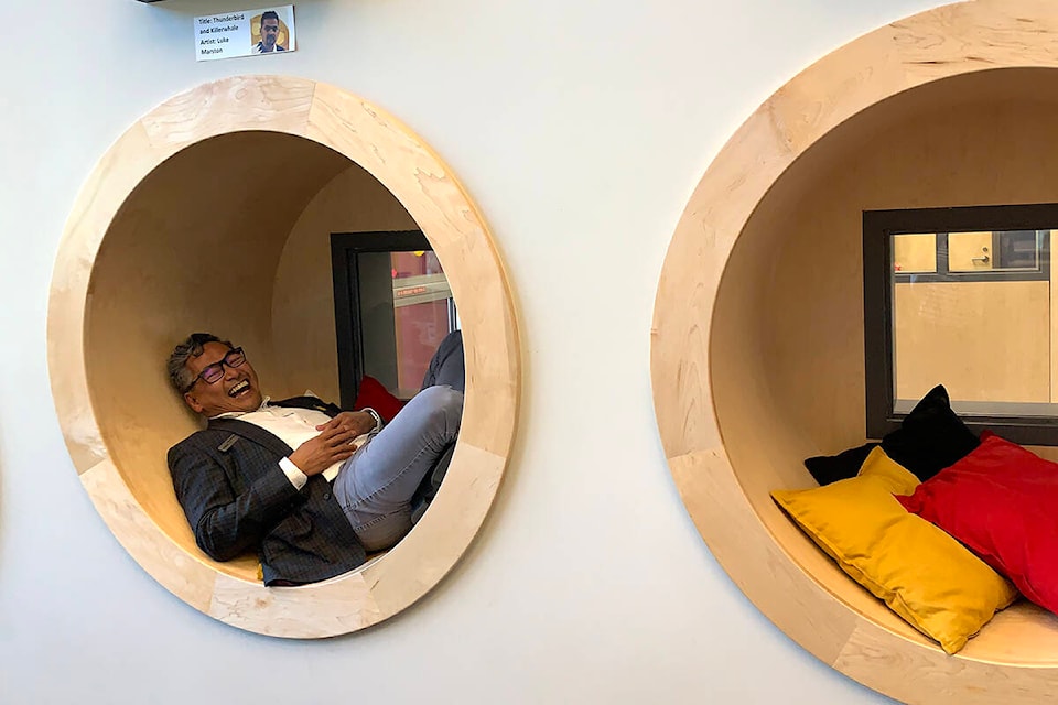 Rod Santiago from Archway Community Services laughs as he tries out the built-in reading nooks in the library at Irene Kelleher Totí:ltawtxw Elementary School in Abbotsford during a tour of the new school. (Jessica Peters/Abbotsford News)