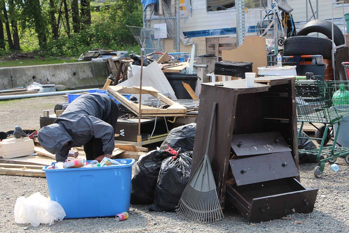 A man sorts through bottles and cans at the Lonzo Road camp. (Vikki Hopes/Abbotsford News)