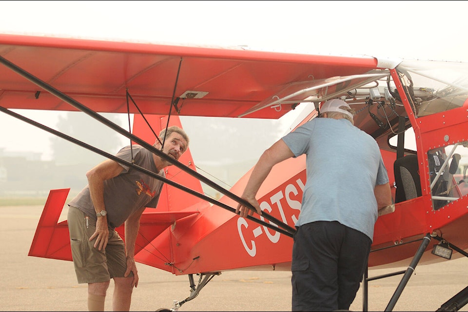 Ken McKeen (left) takes in Chilliwack Flight Fest at the Chilliwack Airport on Sunday, Aug. 20, 2023. The in-flight portion of the airshow was not possible to to poor visibility as a result of smoke from nearby wildfires, but there was lots to see and do on the ground. (Jenna Hauck/ Chilliwack Progress)