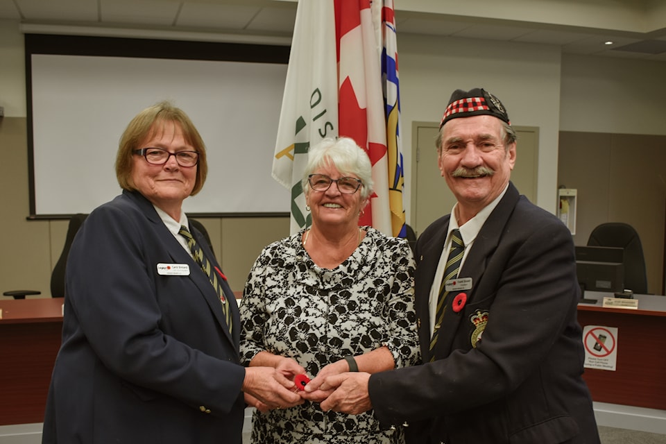 Mayor Sylvia Pranger (centre) of the District of Kent receives the ceremonial first poppy from Agassiz Legion second vice president Carol Breland and president Frank Stover. 