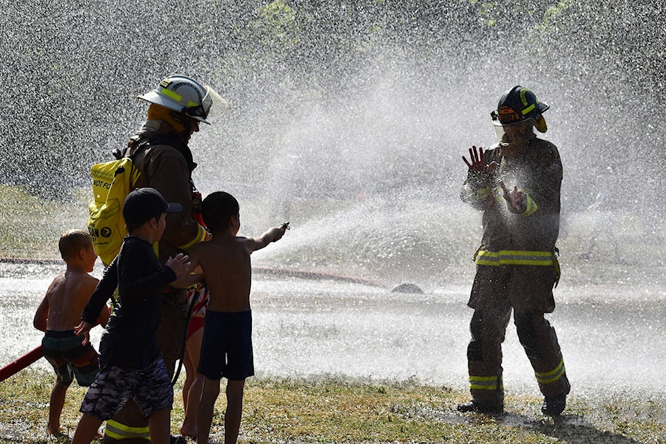 Kids got a chance to use some firefighting equipment to spray each other, their parents and members of the Harrison Fire Department at the temporary splash park Wednesday. (Grace Kennedy/The Observer)