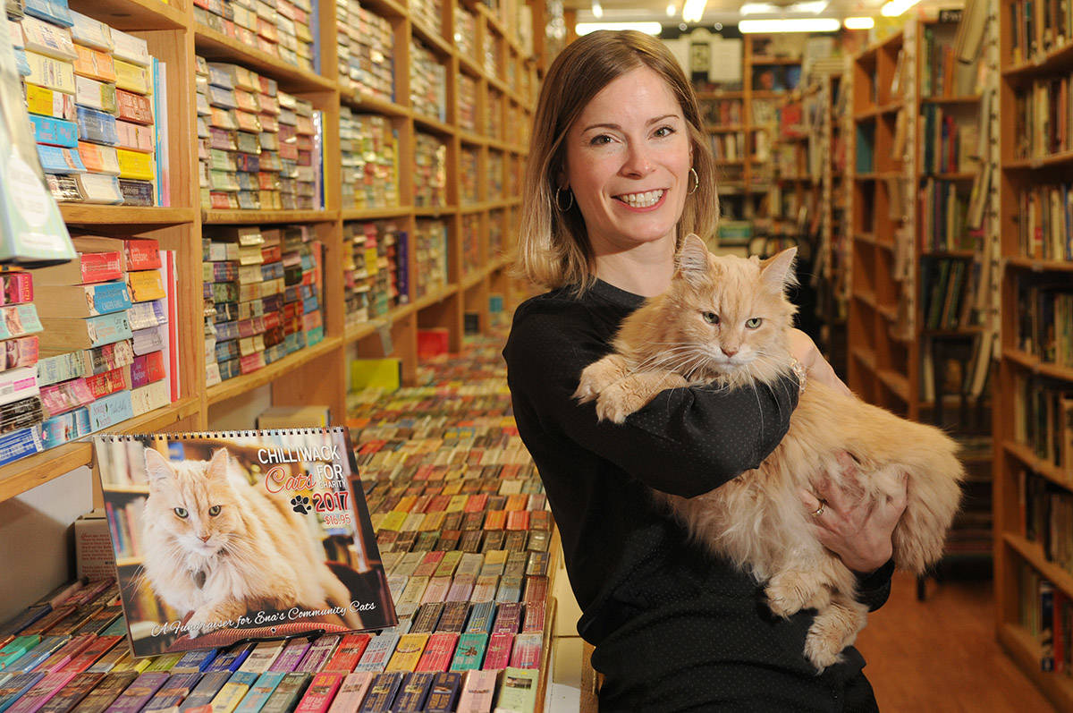 Nietzsche, the ginger cat who worked at The Book Man, poses for a photo with Amber Price on Dec. 15, 2016. Nietzsche died on Monday, Feb. 22, 2021. (Jenna Hauck/ Chilliwack Progress file)