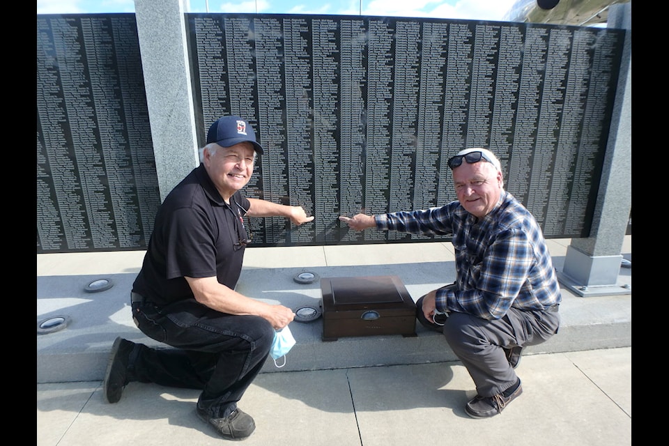 Karl Kjarsgaard, curator from the Bomber Command Museum of Canada (left) and local history buff Theo Gantzert point to Maxwell Calhoun’s name at the BCMC Memorial Wall, where the names of more than 10,000 RCAF members killed in bombers are engraved. Between the men is Calhoun’s box of World War II memorabilia, which was found in Agassiz. (Contributed photo/Karl Kjarsgaard)