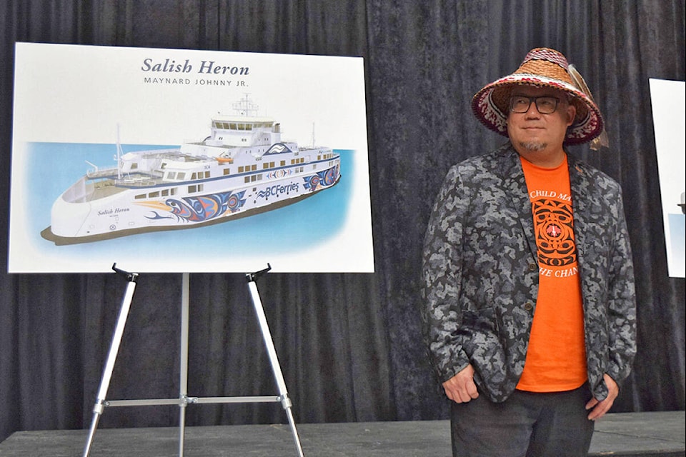 Kwakwaka’wakw and Coast Salish artist Maynard Johnny Jr. beside the unveiled design of the Salish Heron vessel. (Kiernan Green/News Staff)