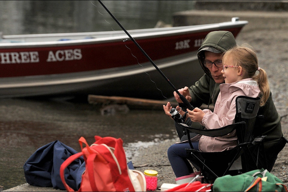Five-year-old Adalyn Geddert gets tips from her grandfather Steve Czeck during the 15th annual Cultus Lake Pikeminnow and Smallmouth Bass Fishing Derby at Main Beach on Saturday, June 18, 2022. (Jenna Hauck/ Chilliwack Progress)