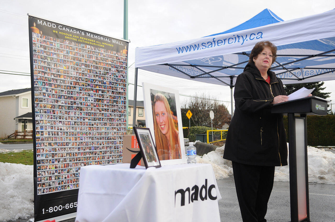 Markita Kaulius speaks during the launch for MADDs six-week impaired driving campaign on Friday, Dec. 9, 2022 at Sardis Secondary School in Chilliwack. Beside her is a photo of her daughter Kassandra Kaulius who was killed by a drunk driver in 2011, and behind her is a poster of hundreds of Canadians who also died because of impaired drivers. (Jenna Hauck/ Chilliwack Progress)