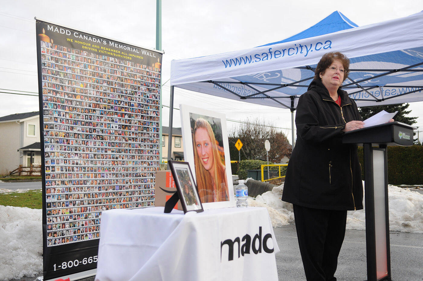 Markita Kaulius speaks during the launch for MADDs six-week impaired driving campaign on Friday, Dec. 9, 2022 at Sardis Secondary School in Chilliwack. Beside her is a photo of her daughter Kassandra Kaulius who was killed by a drunk driver in 2011, and behind her is a poster of hundreds of Canadians who also died because of impaired drivers. (Jenna Hauck/ Chilliwack Progress)