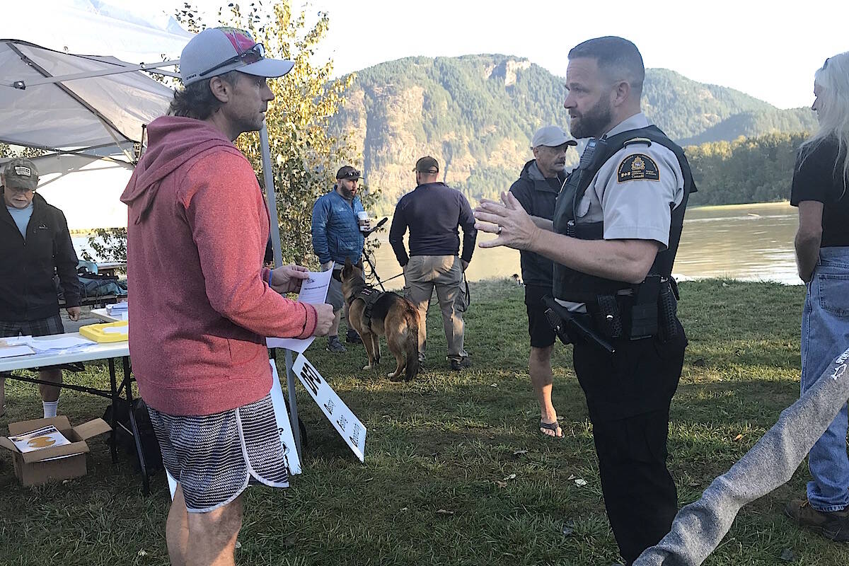 DFO fishery officer Mike Fraser chats with Valdy Widera of Surrey, at the bar-fishing demonstration fishery, Sept. 9, 2020, at Island 22 Regional Park in Chilliwack, explaining the event was not sanctioned by DFO. (Jennifer Feinberg/ Chilliwack Progress file)