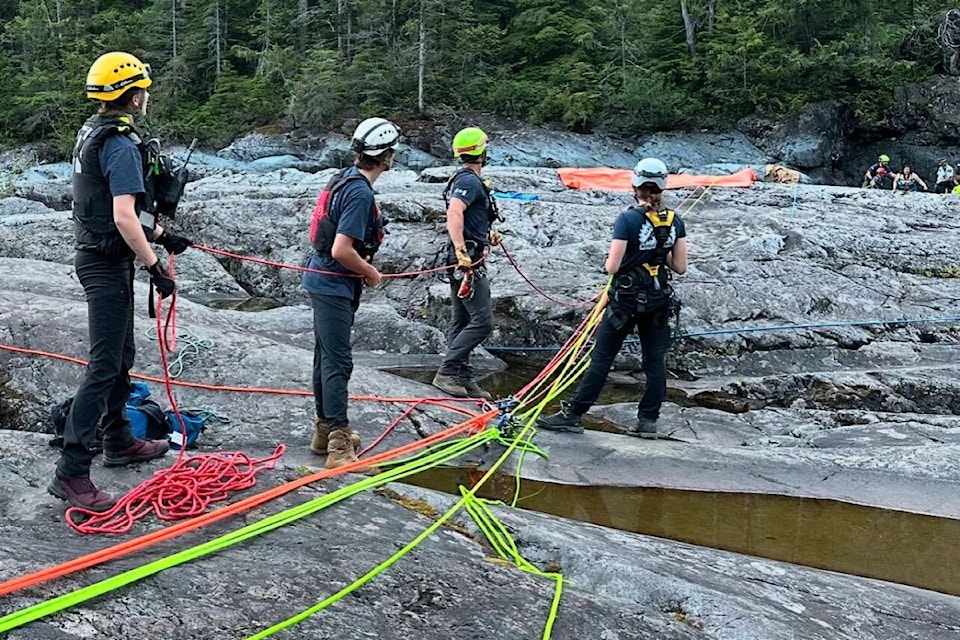 Members of Alberni Valley Rescue Squad and Arrowsmith SAR wait for a swimmer to be lifted from a ravine on Wally Creek on Wednesday, Aug. 14, 2024. The person had been swept downstream and was able to pull themselves up on a log to await rescue. 