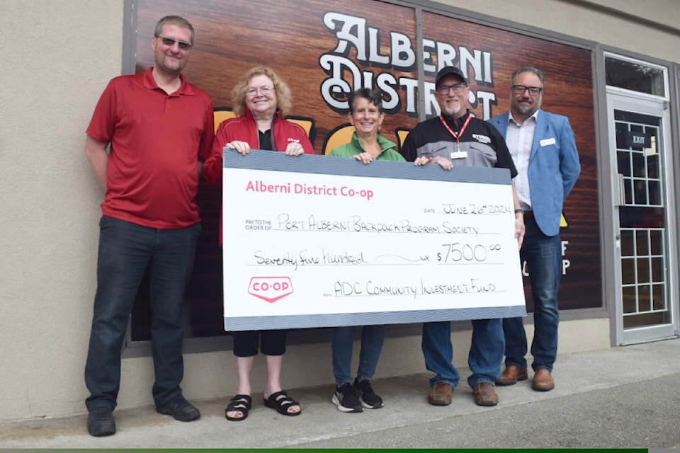 Staff and board members with the Alberni District Co-op provide the Port Alberni Backpack Program Society with a $7,500 donation. 
