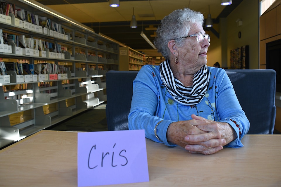 Cris pauses from sharing her story to gaze out the window during the Community Action Team's 'Living Library' event, June 19, 2024 at the VIRL branch in Port Alberni.