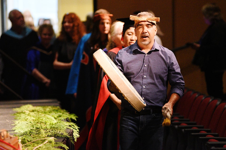 Nuukithima-uk Aaron Watts from Tseshaht First Nation drums and sings as he leads NIC faculty members into the ADSS Theatre during NIC's graduation ceremony June 18, 2024. 