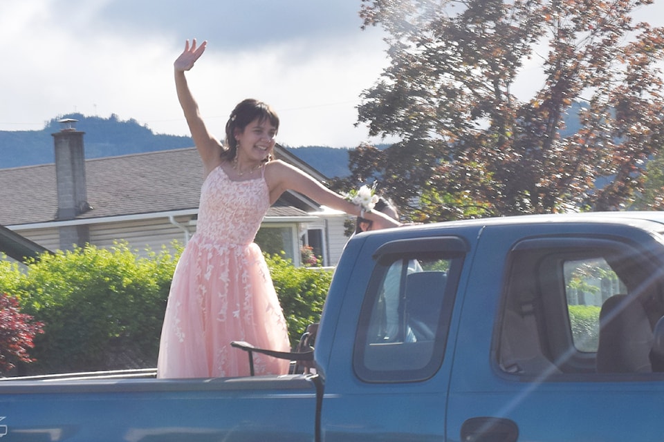 ADSS graduate Kelcie Sam waves at onlookers from the back of her ride during the Prom Parade on Saturday, June 22.