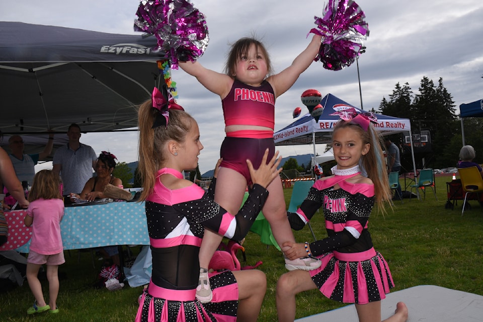 Audrey Pelland, left, and Lacy Lothrop, right, help Raevyn Jeffs, 3, with a cheerleading stunt at the city's Summer Kick-off event at Bob Dailey Stadium on June 21, 2024. The young cheerleaders are from Phoenix Acrobatics, promoting an upcoming summer camp. 